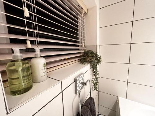 a bathroom with a window and a bottle of soap at Seascape Luxury Cottage Southwold - Free Parking in Reydon