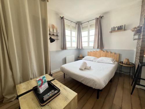 une chambre avec un lit et une table avec un ordinateur portable dans l'établissement Le Marin, à Calais