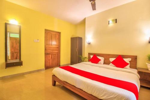 a bedroom with a large bed with red pillows at Roseal Beach Front in Baga