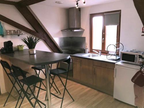 une cuisine avec une table, des chaises et un évier dans l'établissement Duplex 4-6 pers Parking Jardin, à Obernai