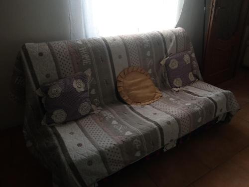a couch with a pillow on it in front of a window at La casa dei poeti in Cervasca