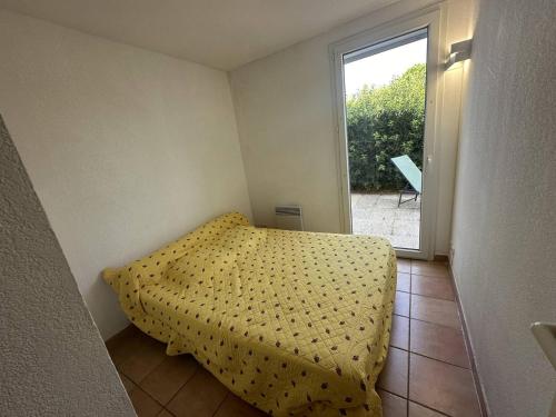 a small bedroom with a bed and a window at G1 Manadiers T3 parking piscine terrasse in Saintes-Maries-de-la-Mer