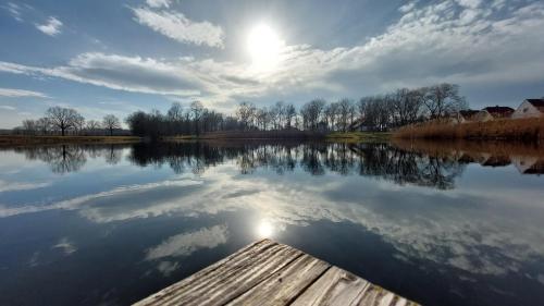 a view of a lake with the sun reflecting on the water at Ferienhaus Radlwiesn in Sankt Margarethen im Burgenland