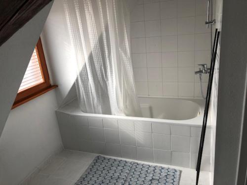 La salle de bains est pourvue d'une baignoire et d'un rideau de douche. dans l'établissement Duplex 4-6 pers Parking Jardin, à Obernai