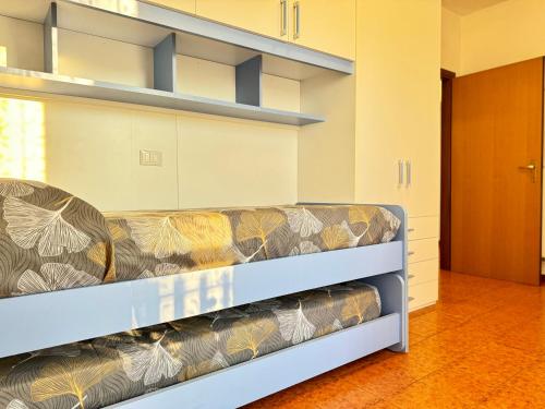 a couch sitting in a room with shelves at 82, Attico Leonardo in Lido Adriano