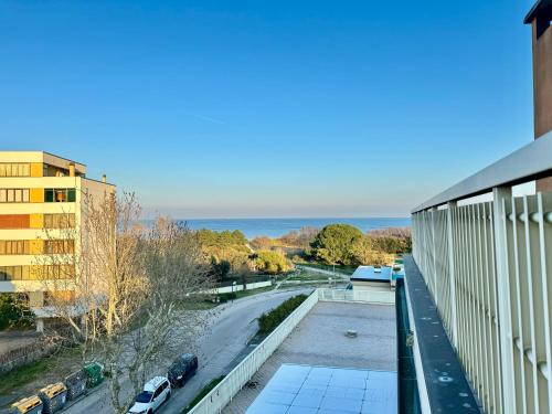 a balcony with a view of a road and the ocean at 82, Attico Leonardo in Lido Adriano