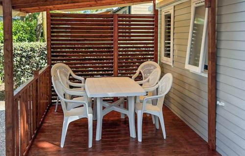 - une table et des chaises sur la terrasse couverte d'une maison dans l'établissement Stunning StaCaravan In Sète, à Mèze