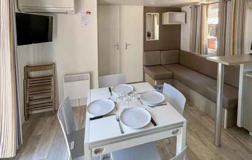 - une table à manger et des chaises blanches dans la chambre dans l'établissement Stunning StaCaravan In Sète, à Mèze