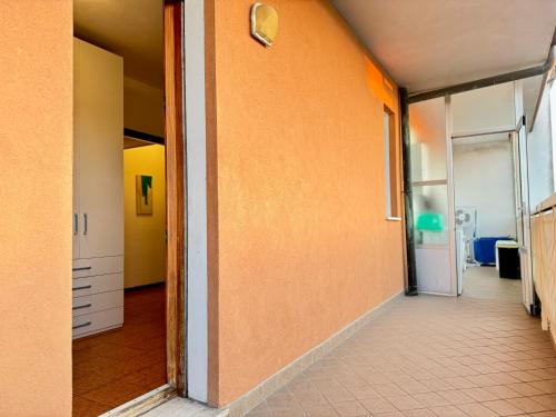 an empty hallway with an orange wall and a door at 82, Attico Leonardo in Lido Adriano