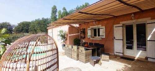 a patio with a building with a kitchen and a grill at La Sousto Du Lac Sauvage in Esparron-de-Verdon