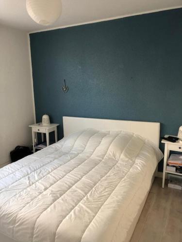 - un lit blanc dans une chambre dotée d'un mur bleu dans l'établissement Sanary-sur-mer superbe appartement au calme, à Sanary-sur-Mer