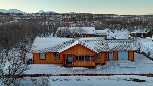 an orange house with snow on the roof at Lovely house in Abisko in Abisko