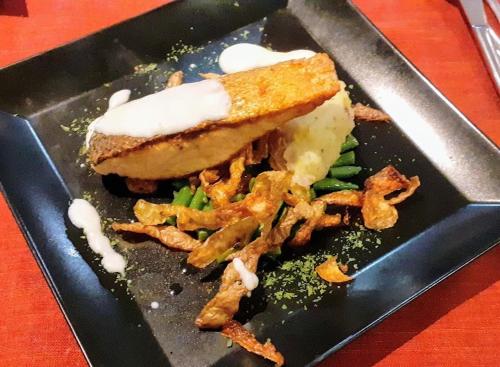a black plate of food with a sandwich and vegetables at Kyriad SEDAN in Sedan