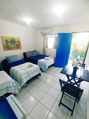a room with two beds and a table and a chair at Ponta Negra Suites & Apart in Natal
