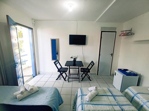 a room with two beds and a table with a television at Ponta Negra Suites & Apart in Natal