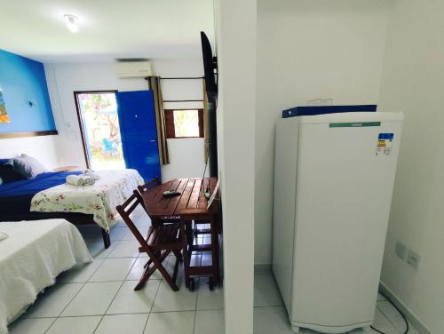 a kitchen with a desk and a refrigerator in a room at Ponta Negra Suites & Apart in Natal