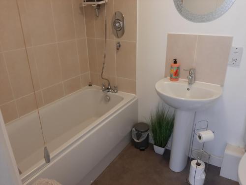 a bathroom with a sink and a tub and a toilet and a sink at Ground Floor Cornish Retreat Free Parking in Bodmin