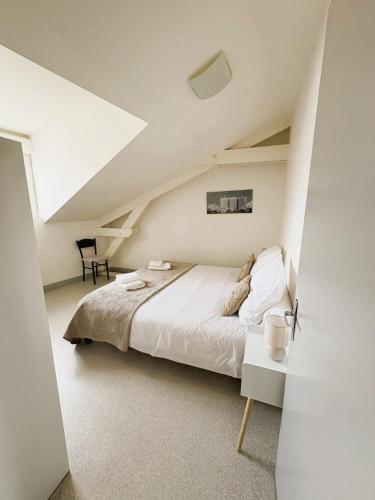 une chambre avec un grand lit dans un grenier dans l'établissement Nid Douillet - En ville - Climatisé, à Périgueux