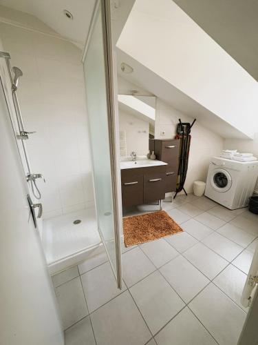 une salle de bain avec douche et lavabo et une machine à laver dans l'établissement Nid Douillet - En ville - Climatisé, à Périgueux