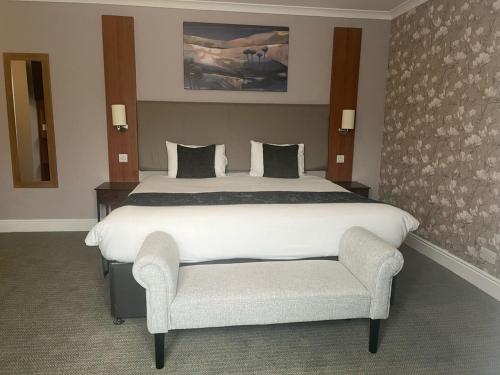 a bedroom with a large white bed and a chair at Wheatsheaf by Chef & Brewer Collection in North Waltham