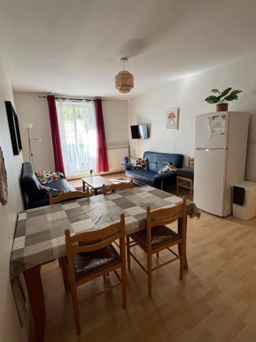 un salon avec une table et un réfrigérateur dans l'établissement Les Platanes - Degas, à Lamalou-les-Bains