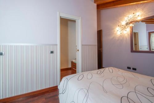 a bedroom with a bed and a mirror on the wall at Villa Ninfa Luxe in Arona