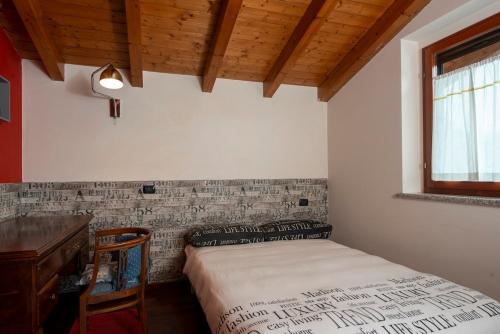 a bedroom with a bed and a desk and a window at Villa Ninfa Luxe in Arona