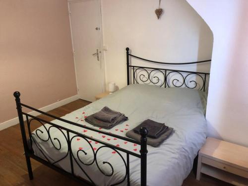 - une chambre avec un lit noir et 2 serviettes dans l'établissement le duplex de la mer, à Le Portel