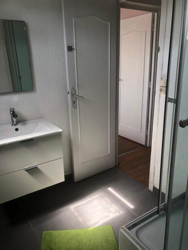 une salle de bain avec une douche, un lavabo et un miroir dans l'établissement le duplex de la mer, à Le Portel