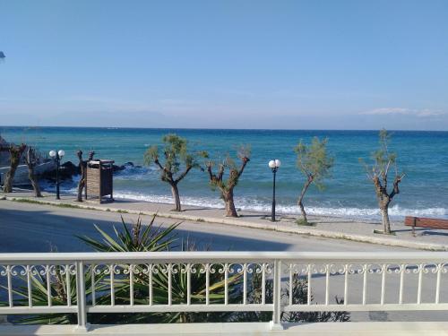 a view of the ocean with a white fence at SereneLands Seaside House in Liyiá