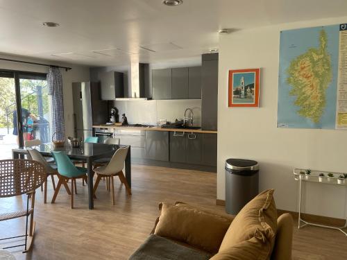un salon et une cuisine avec un canapé et une table dans l'établissement Vacances de rêve à Propriano Grand appartement avec jardin Vue sur le golfe, à Viggianello