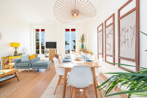 un salon avec une table, des chaises et un canapé dans l'établissement REGINA - Somptueux 3 pièces - carré d'or Menton - vue mer, à Menton