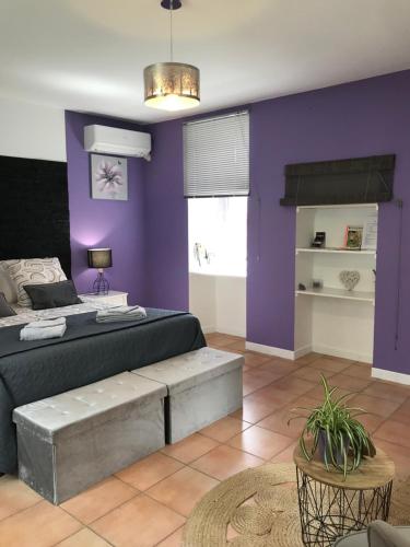 - une chambre avec un lit et un mur violet dans l'établissement Chambre d'hôte Lavande - Le soleil des Cévennes, à Saint-Jean-du-Gard