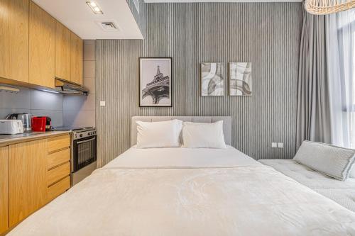 a bedroom with a large bed and a kitchen at Private Tropical Poolside Studio by Blue Cloud Holidays in Sharjah Intl