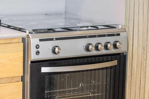 a black and silver stove in a kitchen at Private Tropical Poolside Studio by Blue Cloud Holidays in Sharjah Intl