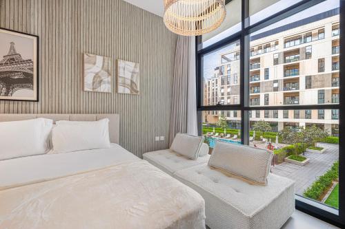 a bedroom with a bed and a large window at Private Tropical Poolside Studio by Blue Cloud Holidays in Sharjah Intl