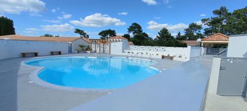 - une piscine au milieu d'un patio dans l'établissement La Grière résidence avec piscine, à La Tranche-sur-Mer