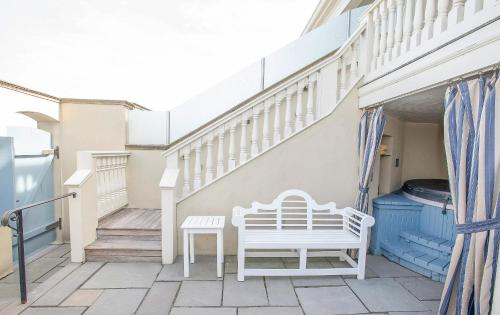 a balcony with a white bench and stairs at The Chanler at Cliff Walk in Newport