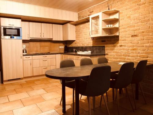 a kitchen with a wooden table and chairs in it at Appart Hotel Au Pied de Vigne in Vresse-sur-Semois