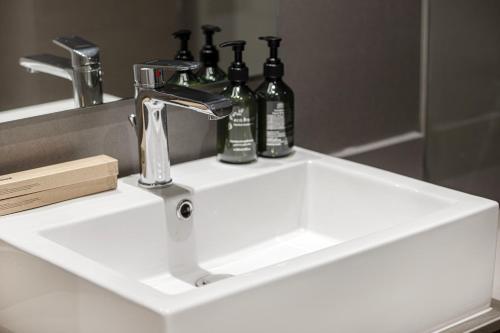 a bathroom sink with bottles sitting on top of it at 1BHK Private Apartment - Dreamers Nest in Sharjah Intl