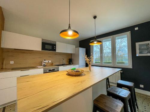 - une cuisine avec un comptoir en bois et 2 chaises dans l'établissement Maison de Cruckin, à Paimpol