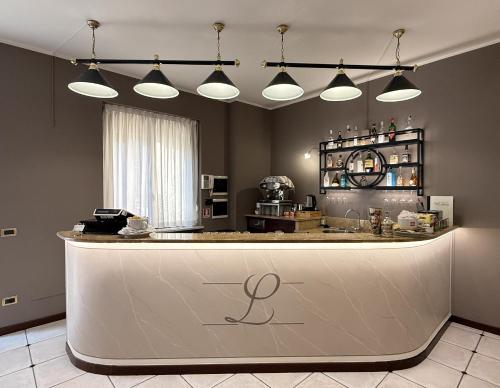a kitchen with a bar with lights above it at Hotel Villa Liberty in Pontecurone
