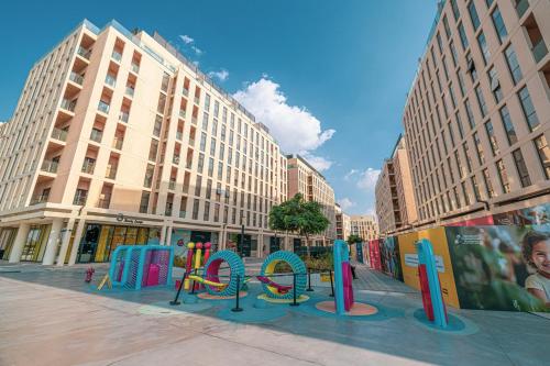 a city street with a playground in front of buildings at Private Tropical Poolside Studio by Blue Cloud Holidays in Sharjah Intl