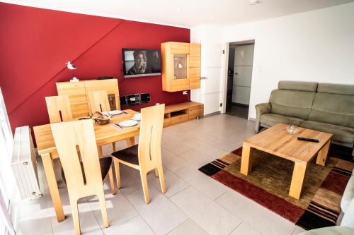 a living room with a table and a couch at Duhner Ausblick mit Balkon in Cuxhaven
