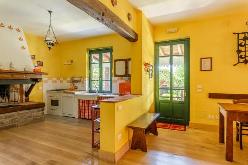 a kitchen with yellow walls and a green door at Rifugio Arcobaleno in Popiglio