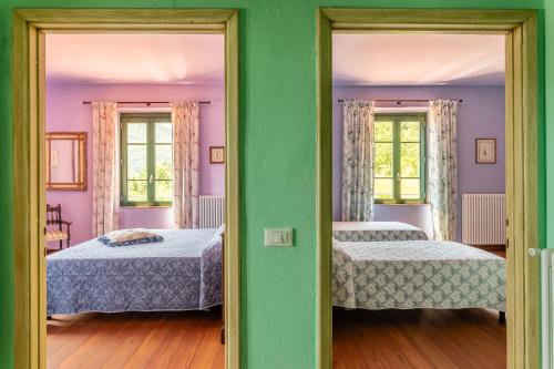 two beds in a room with two windows at Alba al Rifugio Arcobaleno in Popiglio