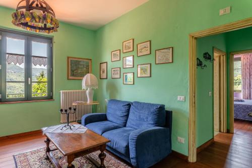 a living room with a blue couch and a table at Alba al Rifugio Arcobaleno in Popiglio