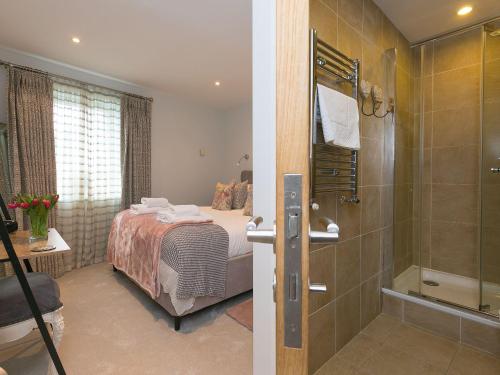 een slaapkamer met een bed en een douche en een badkamer bij Wingspan in St Ives