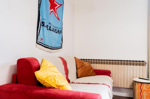 a red couch with yellow pillows in a room at AvocadHouse1QCview in San Pellegrino Terme