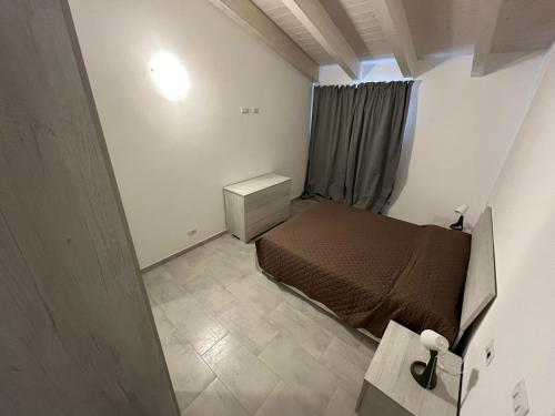 a small bedroom with a bed and a window at Luciano Home in Gonnesa